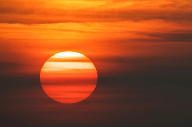 A large red sun setting over the horizon